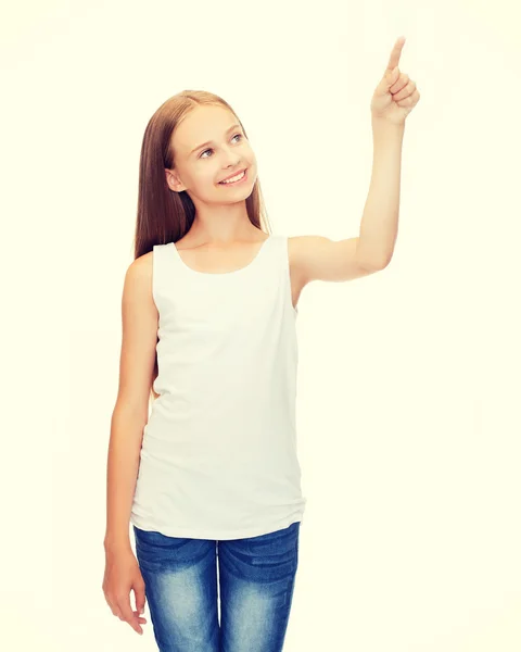 Girl in blank white shirt pointing to something — Stock Photo, Image