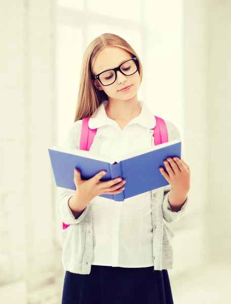 Flickan läsa boken i skolan — Stockfoto