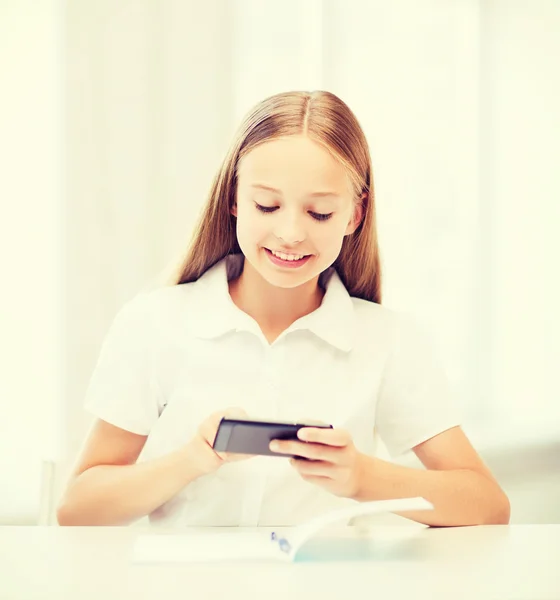 Meisje met smartphone op school — Stockfoto