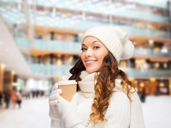 Jonge vrouw in winterkleren met kop glimlachend — Stockfoto