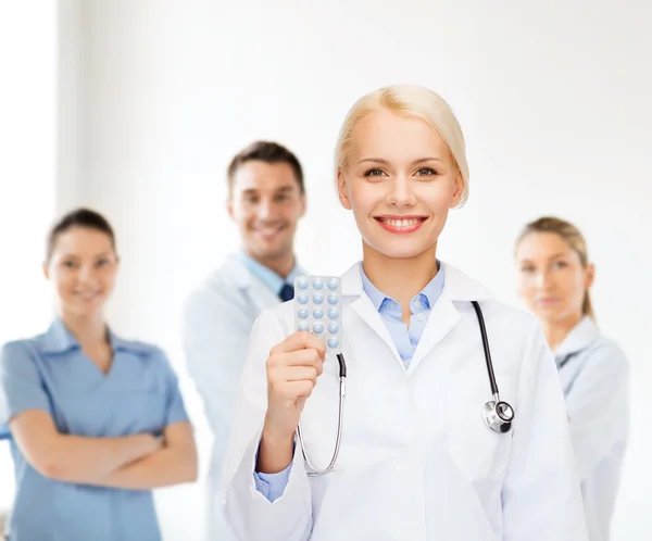 Sorridente medico femminile con pillole — Foto Stock