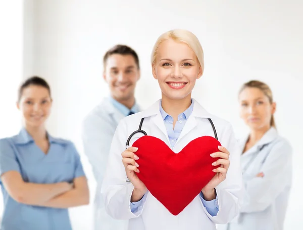 Femme médecin souriante avec cœur et stéthoscope — Photo