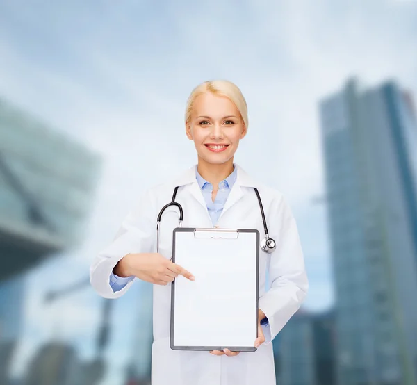 Médecin femme souriante avec presse-papiers — Photo