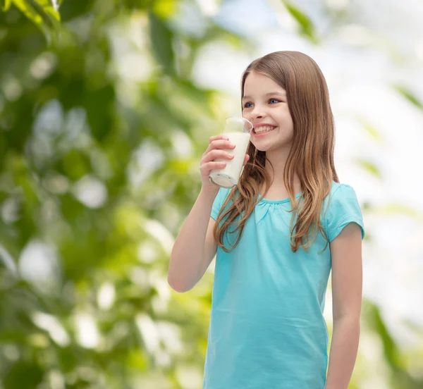 Sorridente bambina che beve latte dal vetro — Foto Stock