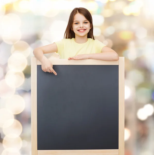 Niña feliz señalando el dedo a la pizarra — Foto de Stock