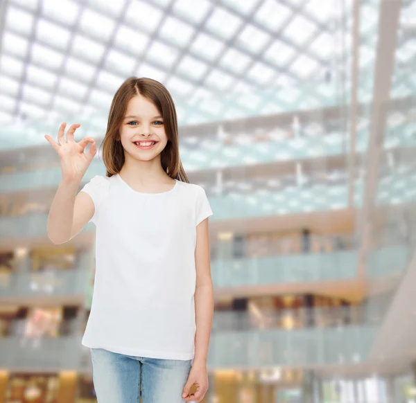 Lächelndes kleines Mädchen in weißem Blanko-T-Shirt — Stockfoto