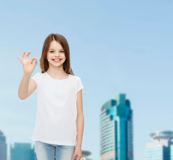 Lächelndes kleines Mädchen in weißem Blanko-T-Shirt — Stockfoto