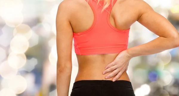 Nahaufnahme einer sportlichen Frau, die ihren Rücken berührt — Stockfoto