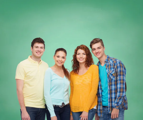 Group of smiling teenagers over green board — Stock Photo, Image