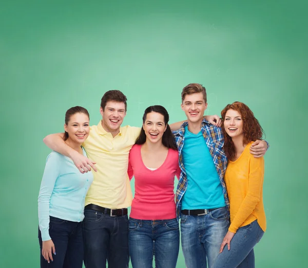 Group of smiling teenagers over green board — Stock Photo, Image