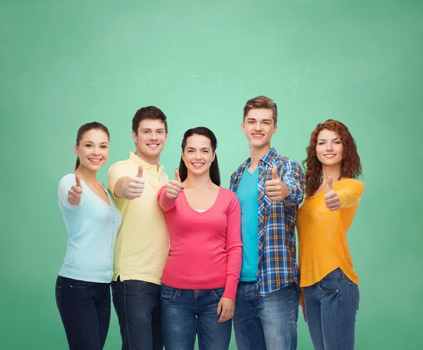 Group of smiling teenagers over green board — Stock Photo, Image