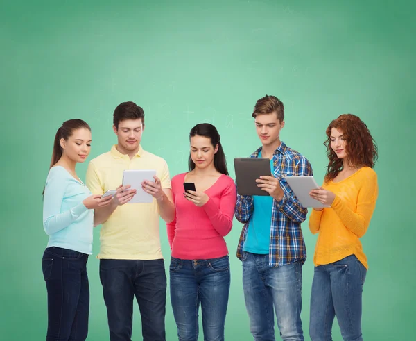 Grupo de adolescentes con teléfonos inteligentes y tableta PC — Foto de Stock