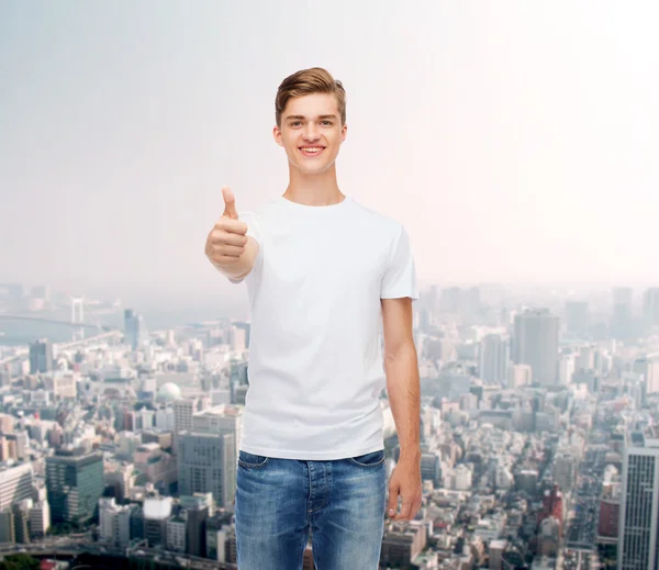 Homme souriant en t-shirt blanc montrant les pouces vers le haut — Photo