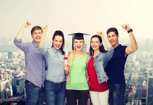 Grupo de estudiantes sonrientes de pie con diploma — Foto de Stock