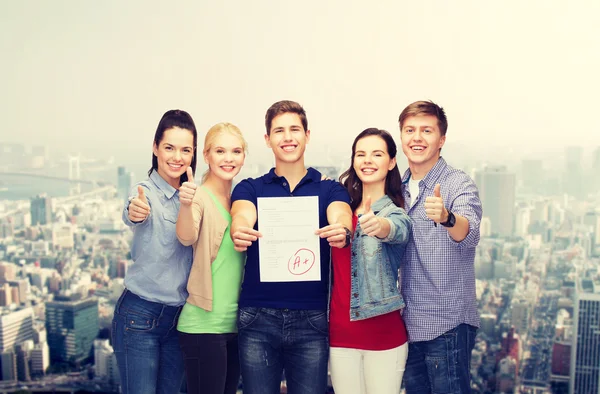 Gruppo di studenti mostrando test e pollici in su — Foto Stock