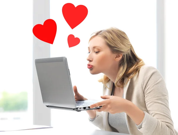 Vrouw verzenden kussen met laptopcomputer — Stockfoto