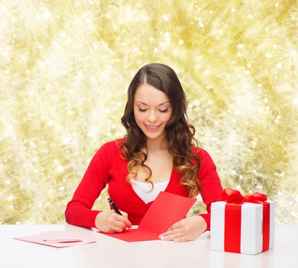 Mujer sonriente con carta de escritura caja de regalo —  Fotos de Stock