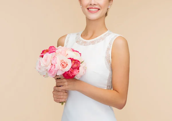 Mulher sorridente em vestido branco com buquê de rosas — Fotografia de Stock