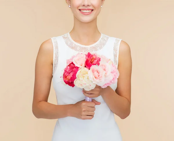 Усміхнена жінка в білій сукні з букетом троянд — стокове фото