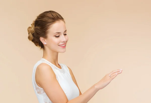 Uśmiechnięta kobieta w białej sukni z pierścionek z brylantem — Zdjęcie stockowe
