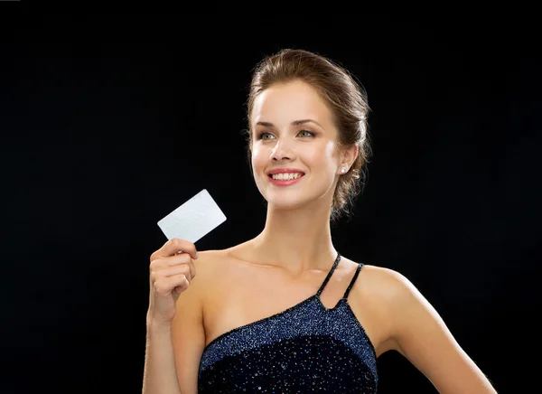 Mulher sorridente em vestido de noite segurando cartão de crédito — Fotografia de Stock