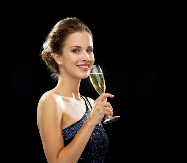 Sonriente mujer sosteniendo un vaso de vino espumoso — Foto de Stock