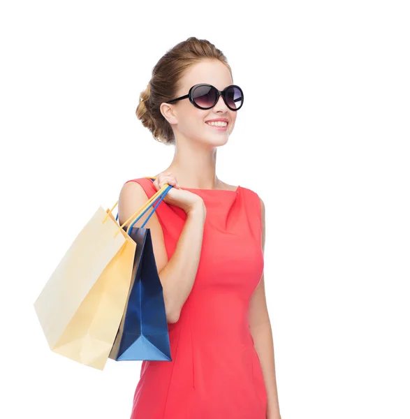 Femme élégante souriante en robe avec des sacs à provisions — Photo