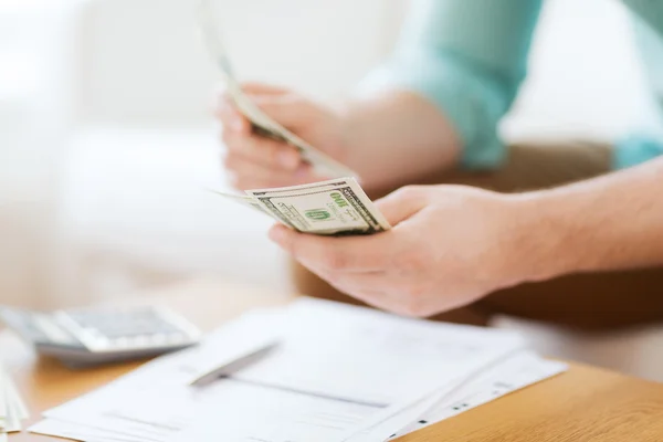 Close up of man counting money and making notes — Stock Photo, Image