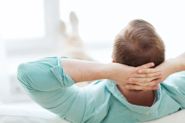 Man lying or sitting on sofa at home from back — Stock Photo, Image