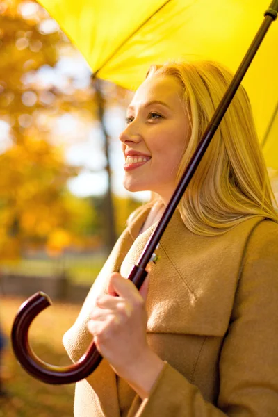 Donna sorridente con ombrello nel parco autunnale — Foto Stock