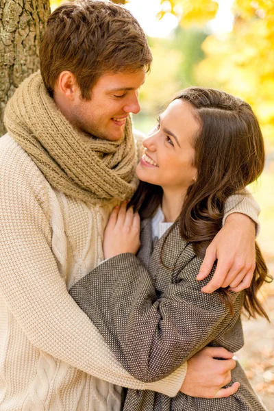 Pareja sonriente abrazándose en el parque de otoño — Foto de Stock