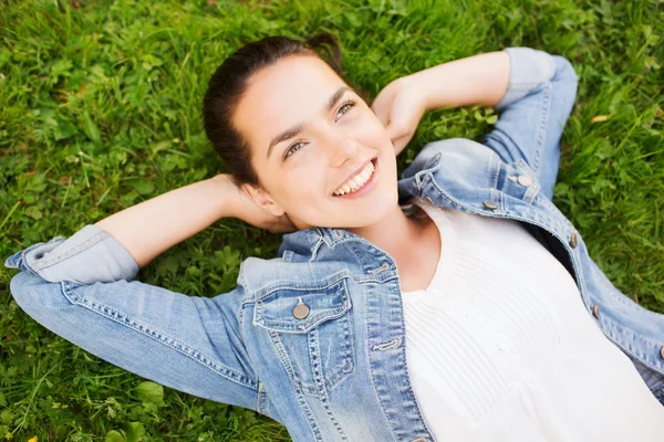 Souriant jeune fille couchée sur l'herbe — Photo