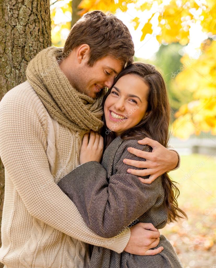 Smiling couple hugging in autumn park Stock Photo by ...