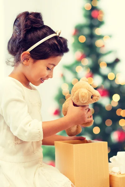 Happy child girl with gift box and teddy bear — Stock Photo, Image