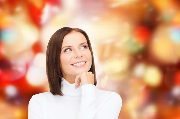 Pensando e sorridendo donna in maglione bianco — Foto Stock