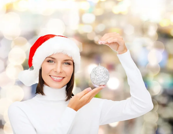 Mulher em santa chapéu ajudante com bola de Natal — Fotografia de Stock