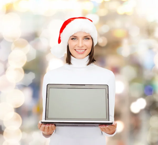 Vrouw in helper kerstmuts met een laptopcomputer — Stockfoto