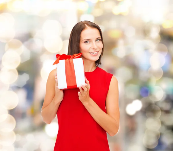 Gülümseyen hediye kutusu ile Kırmızı elbiseli kadın — Stok fotoğraf