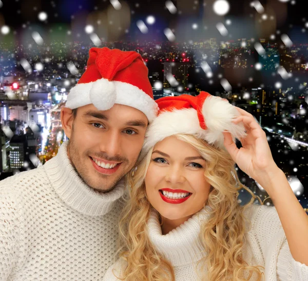 Coppia miiling in maglioni e cappelli Babbo Natale helper — Foto Stock