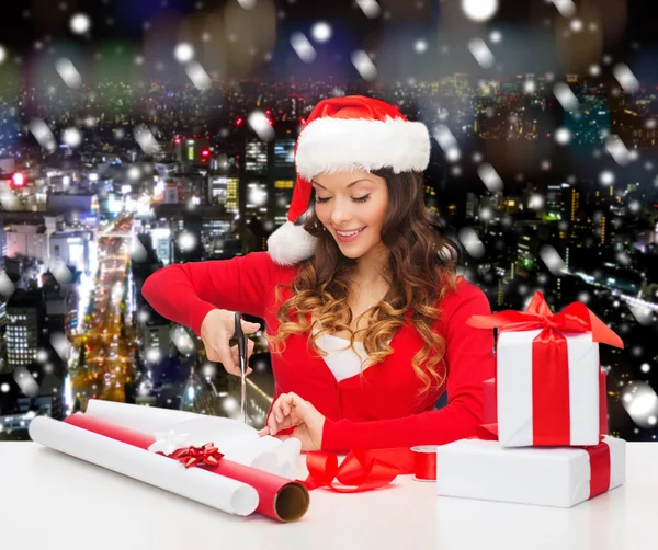 Sonriente mujer en santa helper sombrero embalaje caja de regalo — Foto de Stock