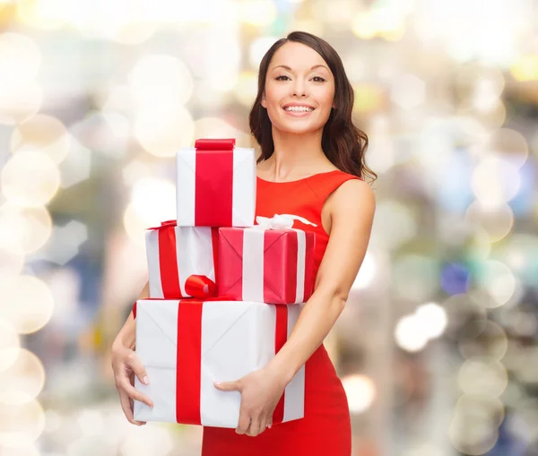 Улыбающаяся женщина в красном платье с подарочной коробкой — стоковое фото