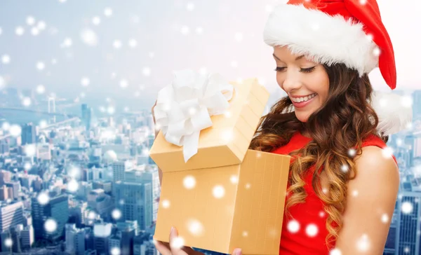 Mujer sonriente en sombrero de ayudante de santa con caja de regalo — Foto de Stock