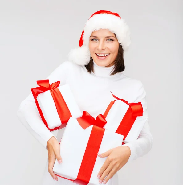 Kvinna i santa helper hatt med många presentförpackning — Stockfoto
