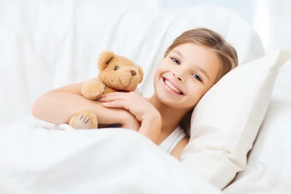 Menina com ursinho dormindo em casa — Fotografia de Stock