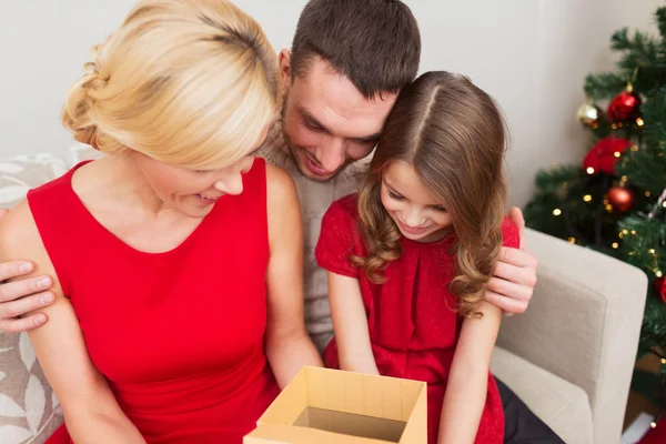 Lycklig familj öppna presentförpackning — Stockfoto