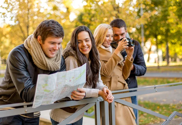 Groep vrienden met kaart en camera outdoors — Stockfoto