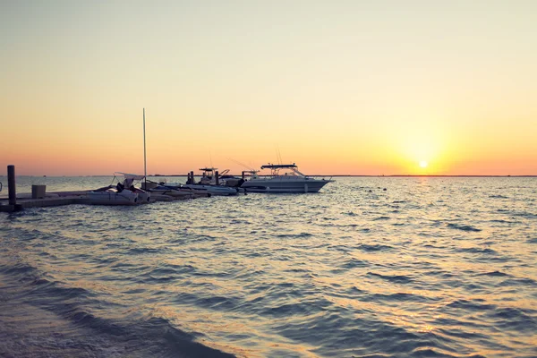 Boten afgemeerd naar pier bij zonsondergang — Stockfoto