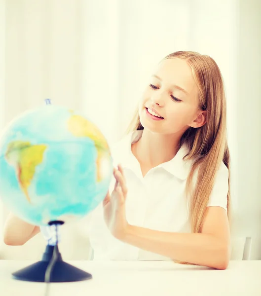 Schülerin mit Globus in der Schule — Stockfoto