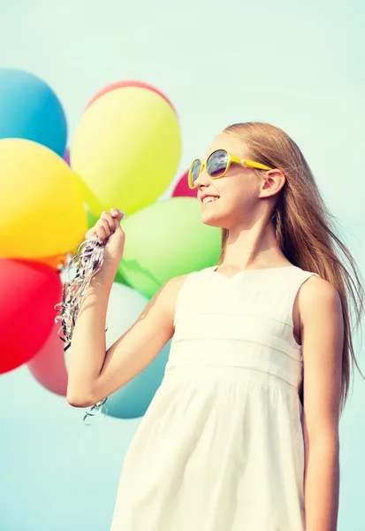 Счастливая девушка с красочными воздушными шарами — стоковое фото