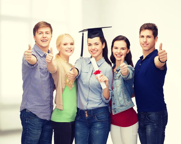 Grupp studenter med diplomet visar tummen — Stockfoto
